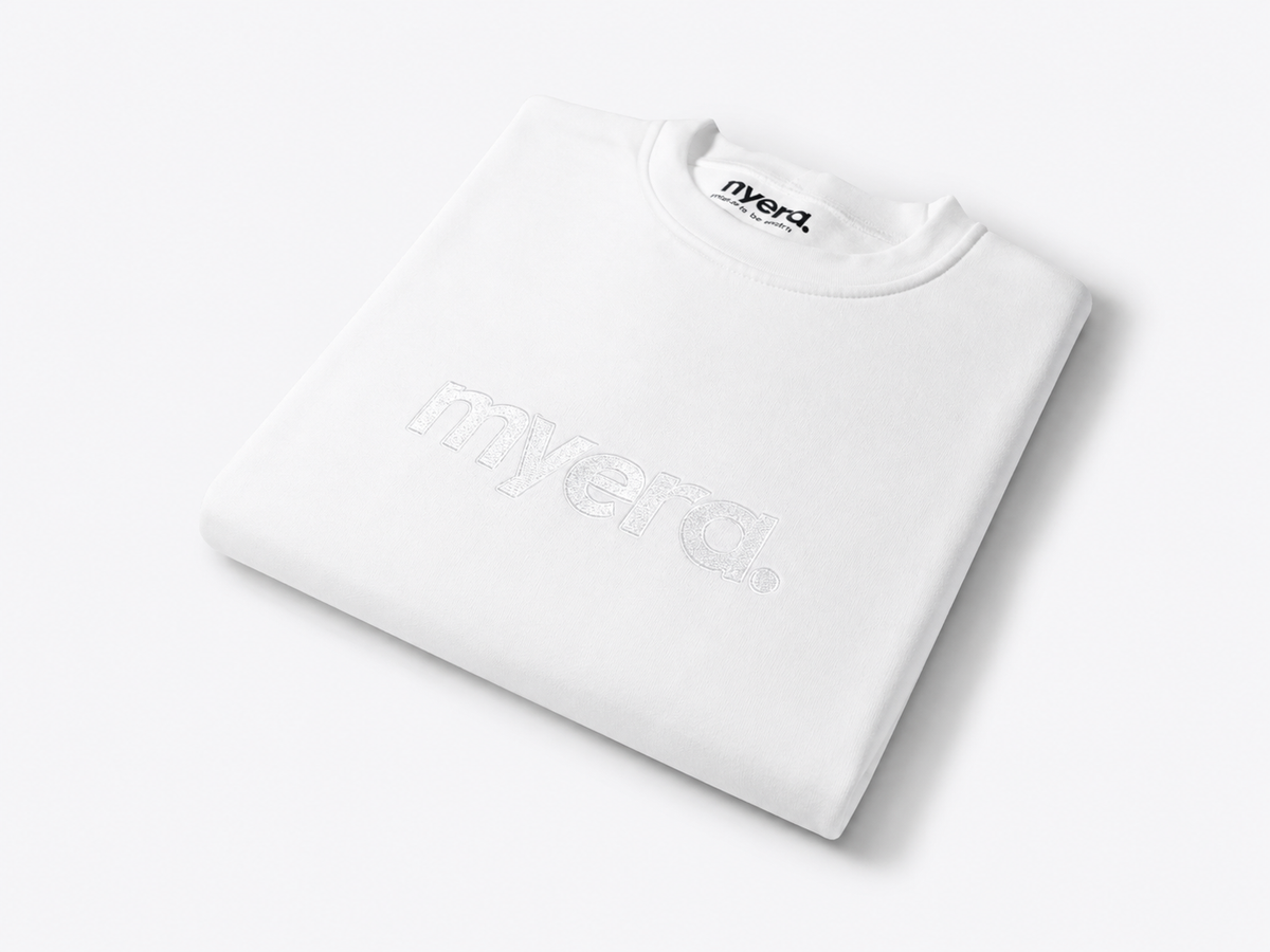 A folded white crewneck sweatshirt with a subtle tonal 'myera.' logo embroidery on the front, displayed on a clean white background.